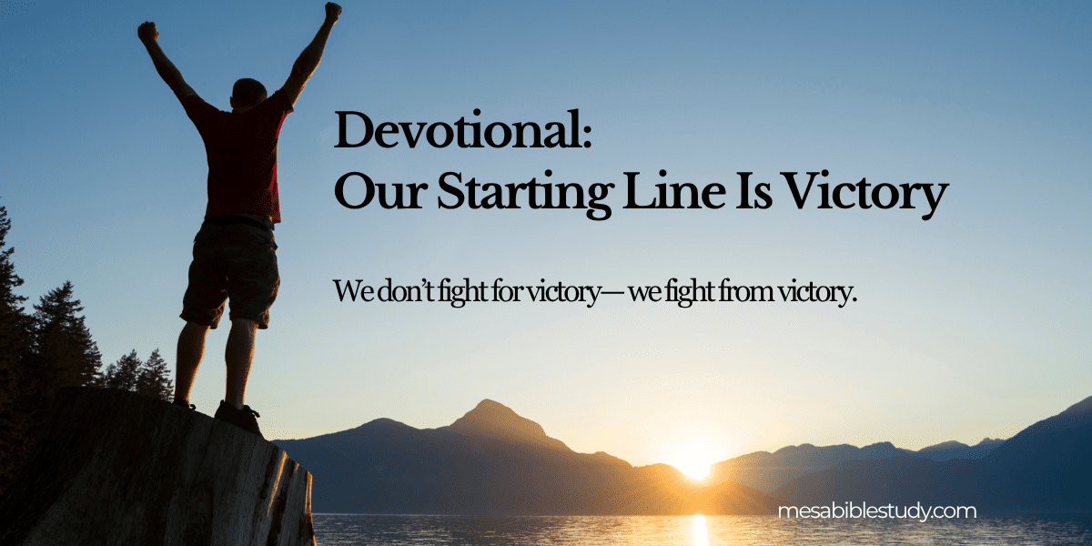 Devotional Our Starting Line Is Victory (2) Man on mountain top with hands up in victory.
